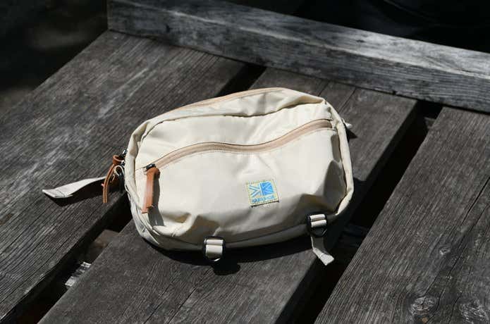 晴れた日の野外、木のベンチに置かれたカリマーのウエストバッグ「VT hip bag R」