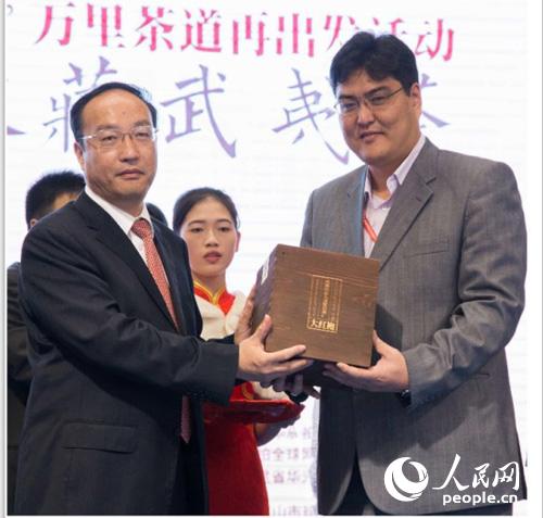 武夷山市委书记马必刚(左)向蒙古国家博物馆代表照日格图(右)移交武夷茶