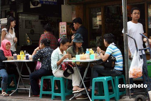 中国侨网资料图:在曼谷市区街道两旁的地道小吃吸引不少游客品尝。