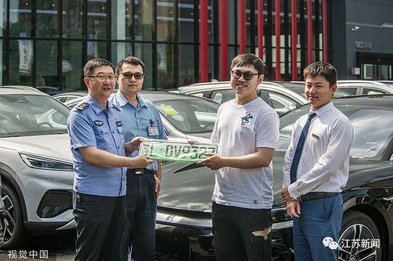 △2023年6月26日,江苏镇江,车主线上选号,车管所工作人员将新车牌照送到车主手中。